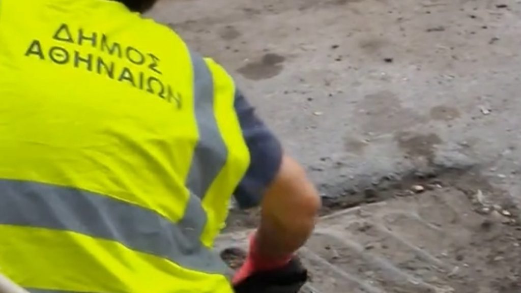 Υπάλληλος του Δήμου Αθηναίων καθαρίζει με τα χέρια φραγμένο φρεάτιο (βίντεο)
