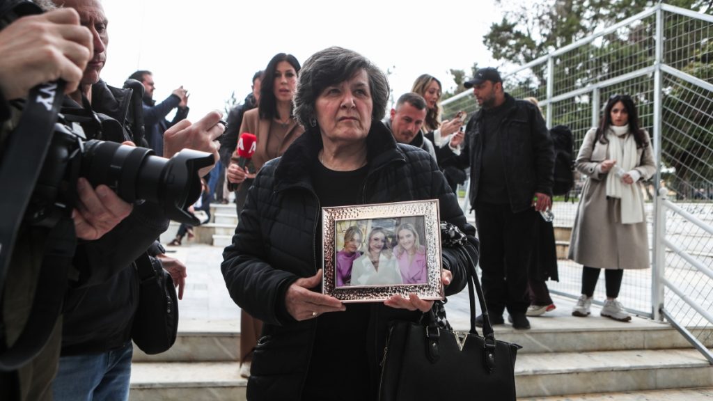 Δίκη για Τέμπη: Η γιαγιά των κοριτσιών της οικογένειας Πλακιά κρατάει στην αγκαλιά της μία κορνίζα με τις εγγονές της (φωτογραφίες)