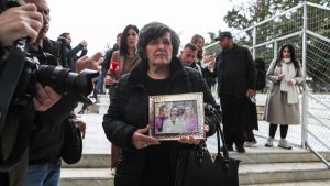 Δίκη για Τέμπη: Η γιαγιά των κοριτσιών της οικογένειας Πλακιά κρατάει στην αγκαλιά της μία κορνίζα με τις εγγονές της (φωτογραφίες)